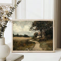 Framed farm landscape on a white console with vase