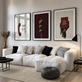 Three-piece burgundy and olive gallery wall set above a modern white sectional