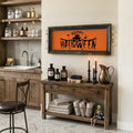 Happy Halloween scarecrow artwork in a distressed dark frame above a rustic vanity