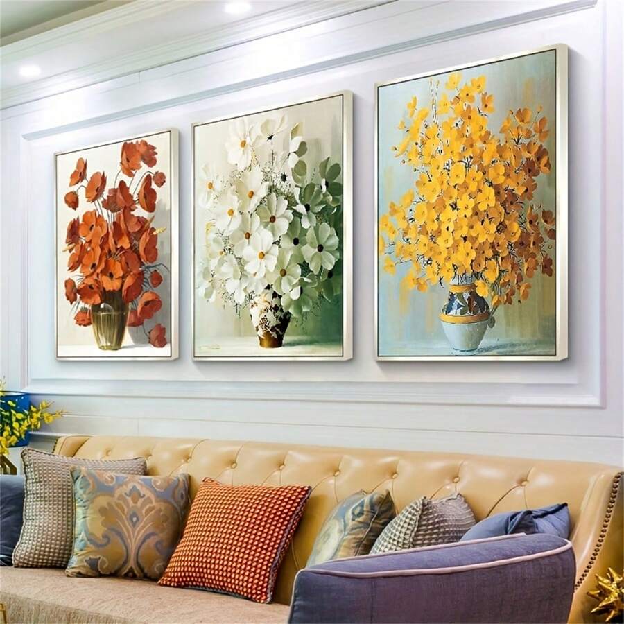 Three floral bouquet canvases arranged over a sofa in a modern living room