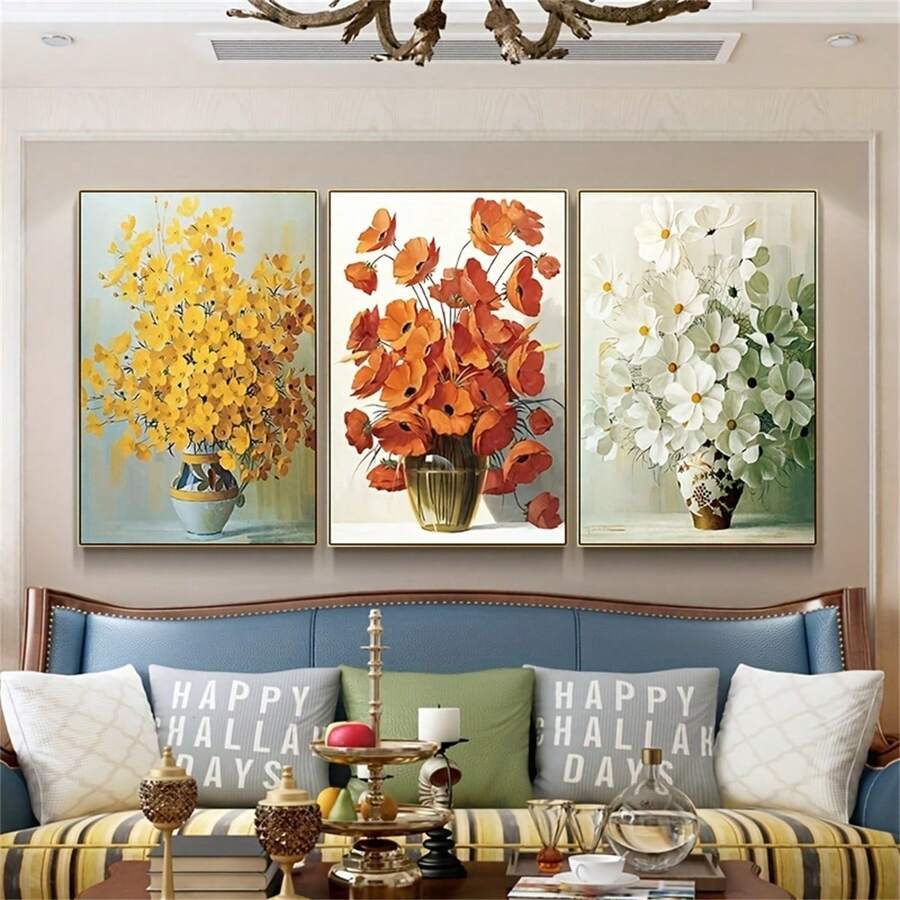 Three vase flower posters above a blue sofa in a bright sitting room