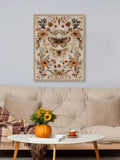Framed moth and sunflower print above a cozy tufted sofa