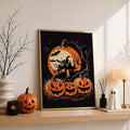 Gold-framed Halloween haunted house print on a light wood shelf