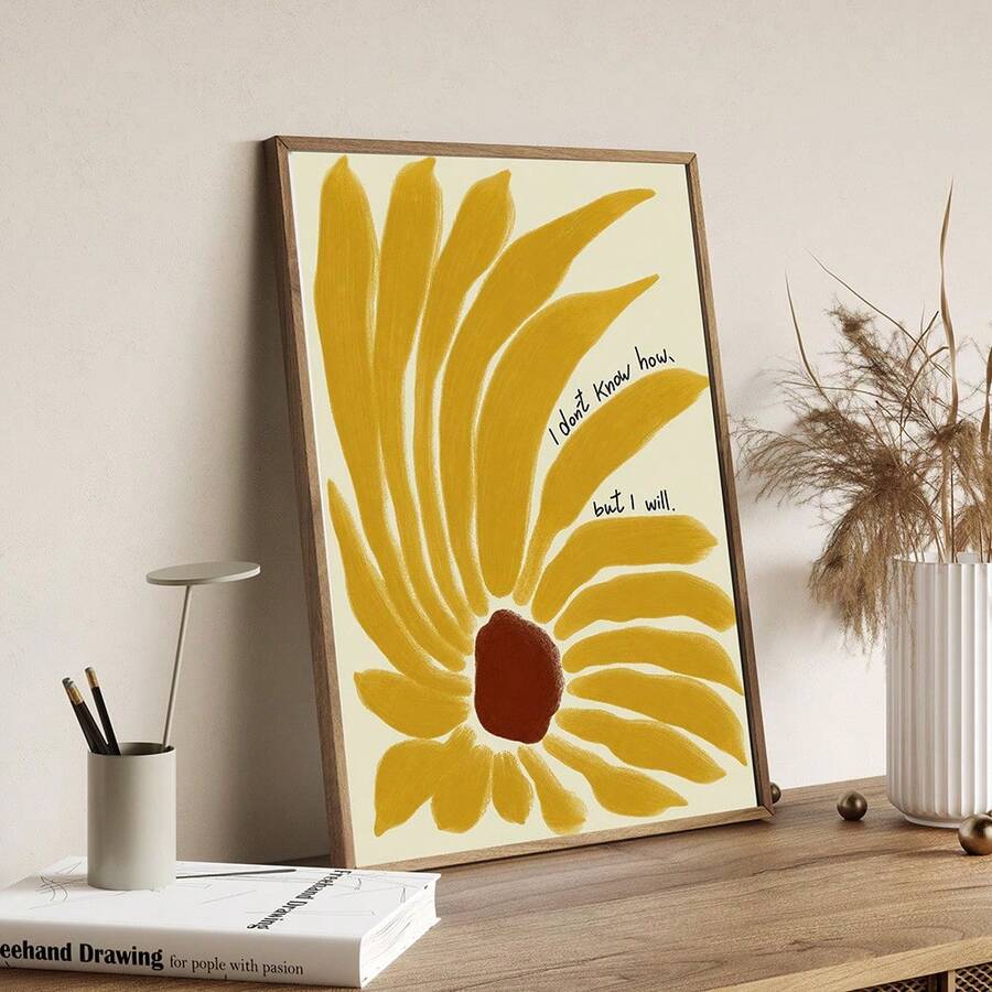 Natural wood-framed yellow sunflower motivational print displayed on a wooden desk