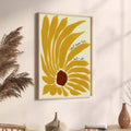 Light wood-framed sunflower quote wall art beside neutral ceramics and pampas grass