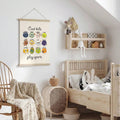 Sports themed children’s canvas hanging beside a nursery bed and rocking chair