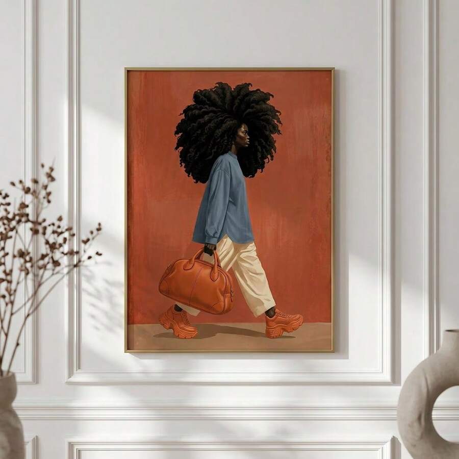 Framed fashion artwork of a Black woman with curls, blue shirt, and orange handbag above a brown sofa