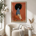 Framed Black woman fashion portrait above a boucle chair with a blue shirt, cream trousers, and orange handbag