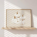 Light-wood-framed minimalist pumpkin wall art displayed on a floating shelf