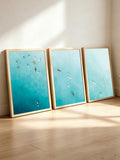 Framed teal ocean surf poster triptych displayed in a sunlit minimalist interior