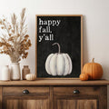 Happy fall y’all pumpkin wall art styled on a wooden sideboard with dried grasses