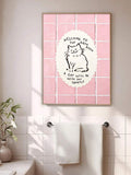 Framed pink cat bathroom sign beside white towels in a bright bathroom