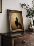 Vintage witch moon print in a rustic frame beside a glowing jack-o-lantern