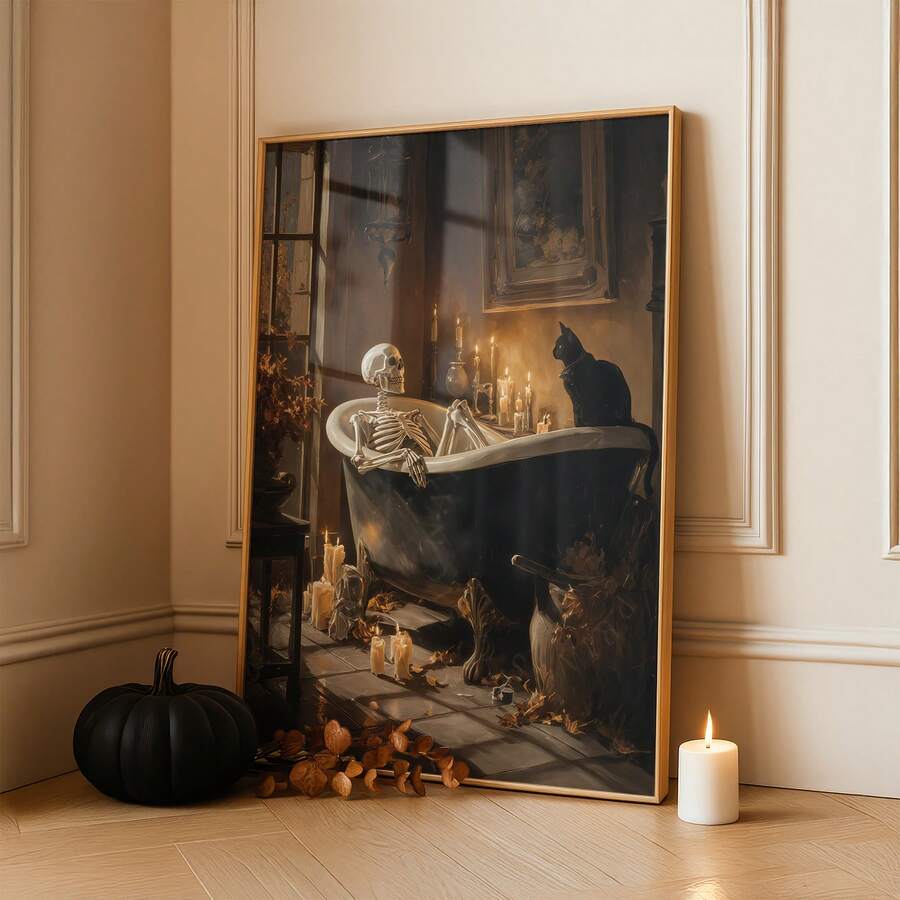 Gothic skeleton and black cat bathtub poster in a slim gold-toned frame beside a black pumpkin and candle