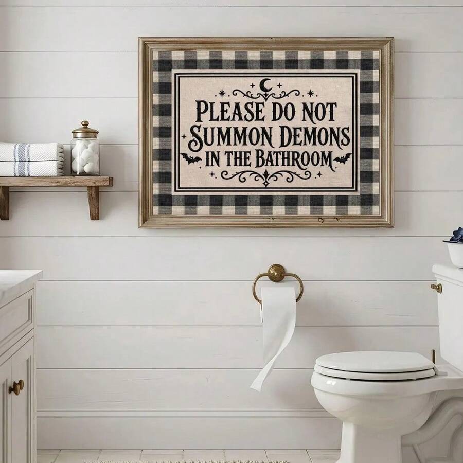 Framed demon bathroom sign displayed above a toilet in a bright washroom
