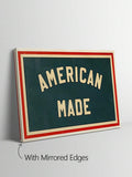 Close view of distressed AMERICAN MADE lettering and red cream border on green canvas