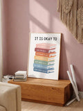 Framed colorful book stack poster styled on a pink-toned shelf