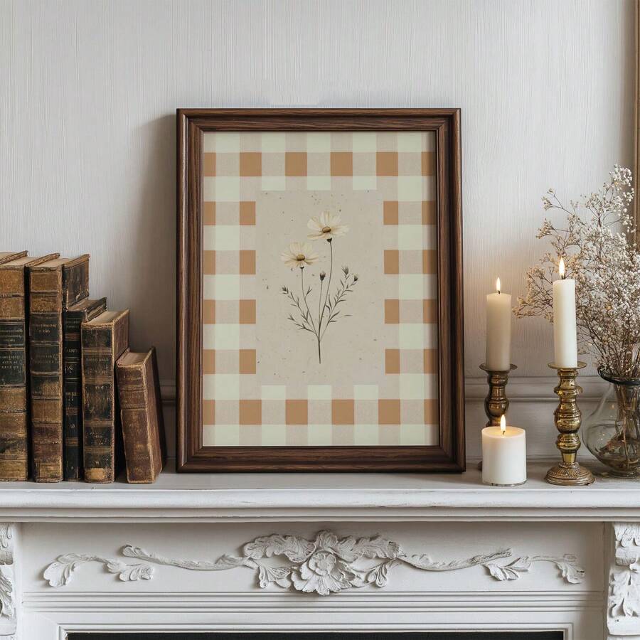 Dark wood framed daisy gingham artwork on a vintage mantel with books, candles, and dried flowers