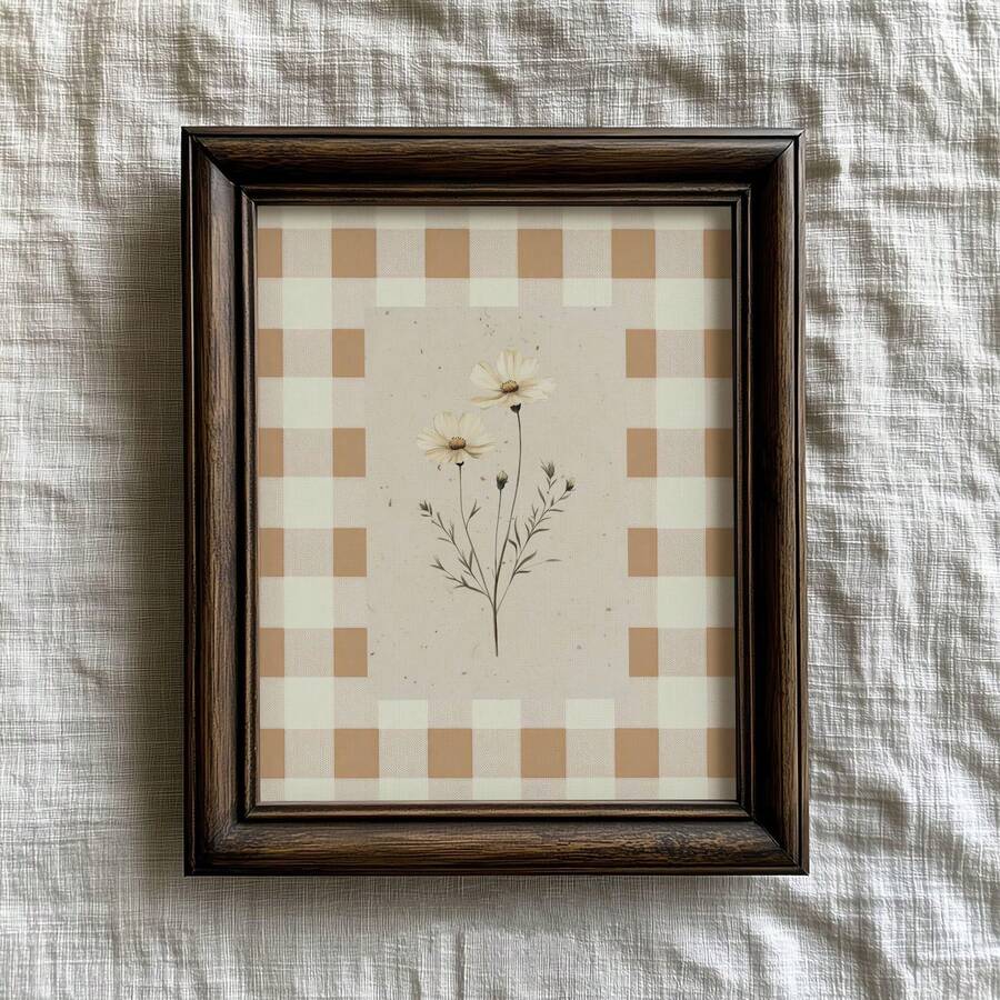 Dark wood framed daisy print with a beige gingham border on textured white linen