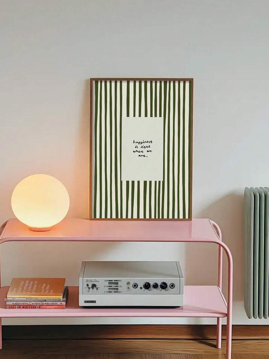 Framed olive green stripe quote wall art displayed above a pink console in a home office