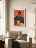 Teal clothing woman portrait canvas poster above a cream armchair