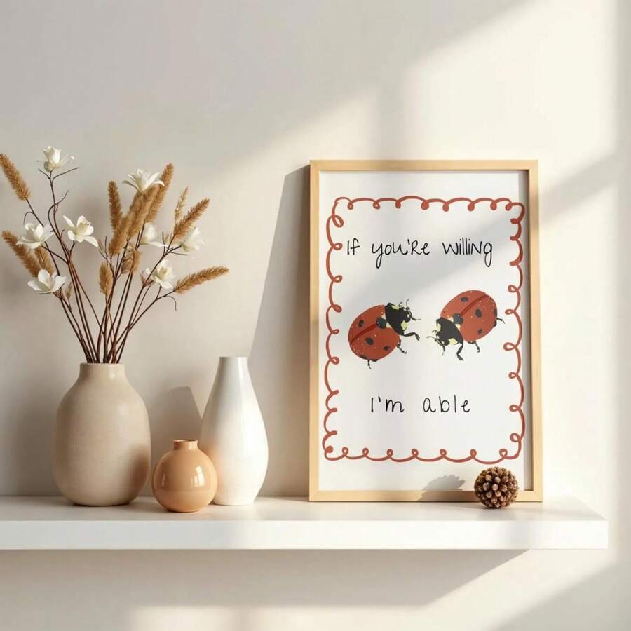 Light wood-framed ladybug wall art on a sunlit shelf with neutral vases and dried flowers