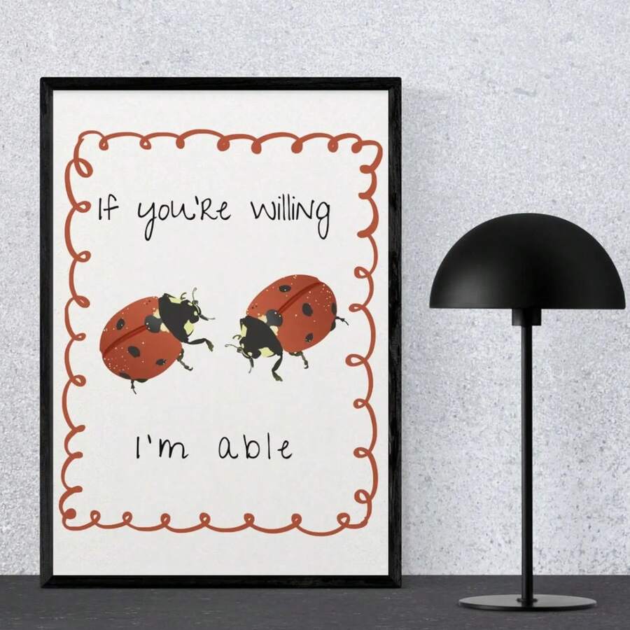 Straight-on view of black-framed retro ladybug poster beside a black dome lamp