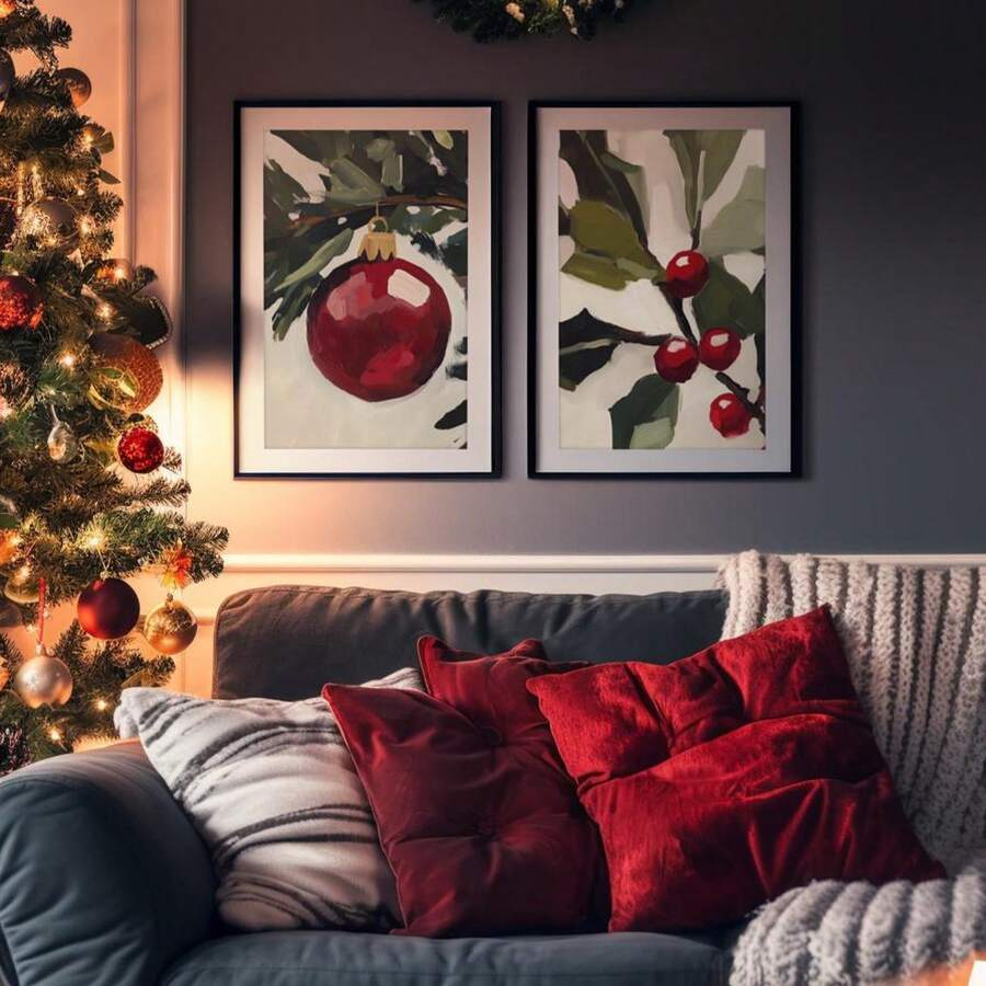 Christmas ornament and holly art above a sofa beside a lit tree and red cushions