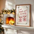 Holiday cocktail typography wall art displayed in a warm wood frame near a Christmas dining table