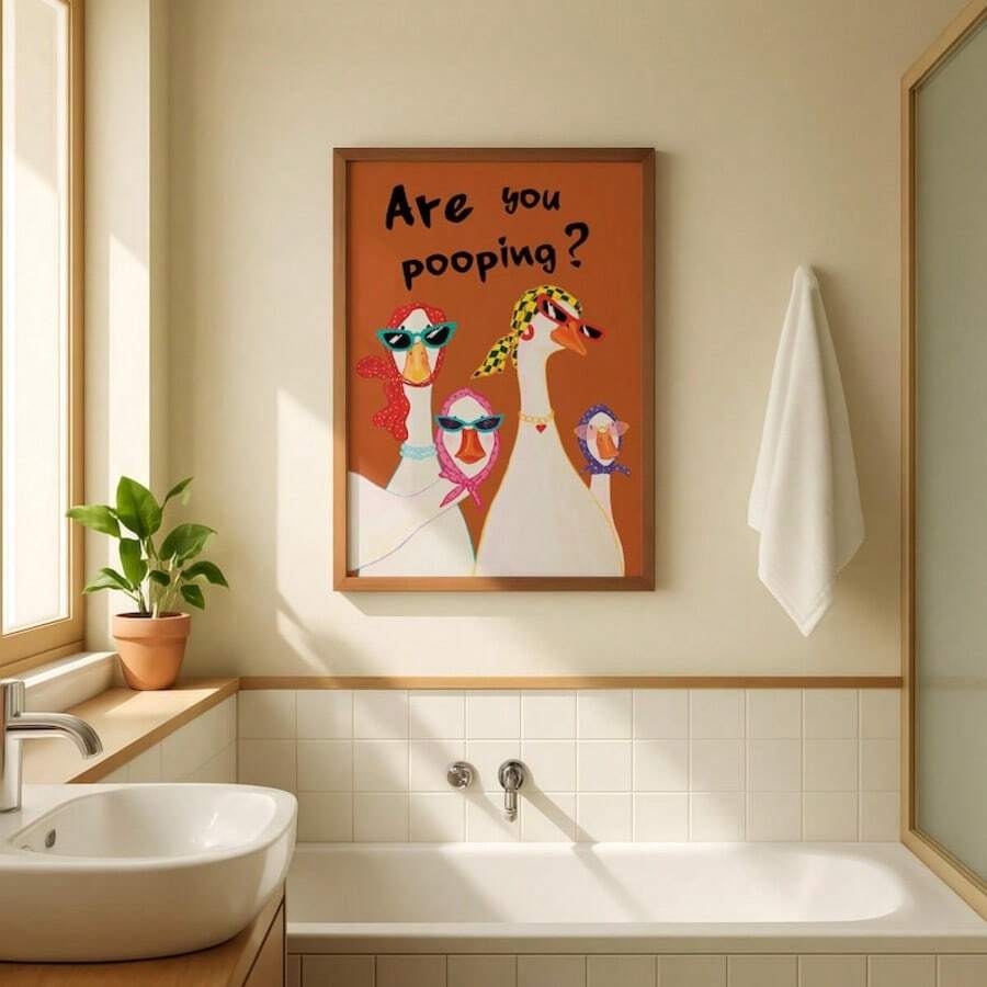 Pink orange goose quote poster in a brown frame in a bathroom