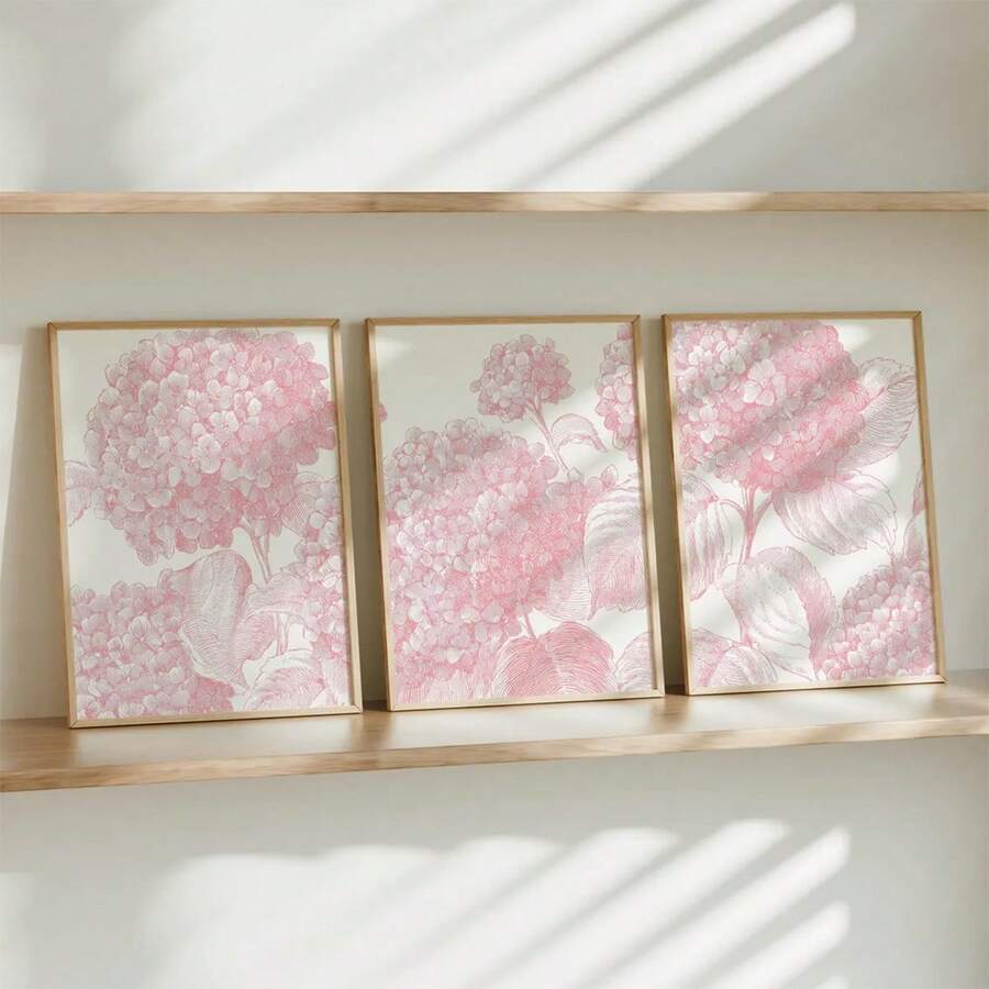 Light pink floral posters styled above a shelf with pale wood accents