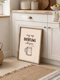 Christian coffee canvas poster leaning against warm white kitchen cabinetry