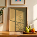 Wood-framed botanical window shadow canvas print styled with pears and an orange on a sunlit tabletop