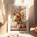 Framed autumn bouquet and pumpkin wall art beside a woven basket and dried foliage