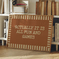 Funny game room wall art in a light wood frame beside a leafy houseplant