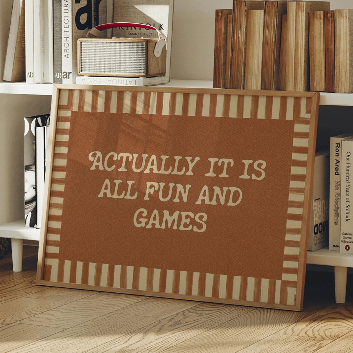 Funny game room wall art in a light wood frame beside a leafy houseplant