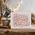 Neutral Christmas canvas print displayed with a small evergreen tree and warm lights