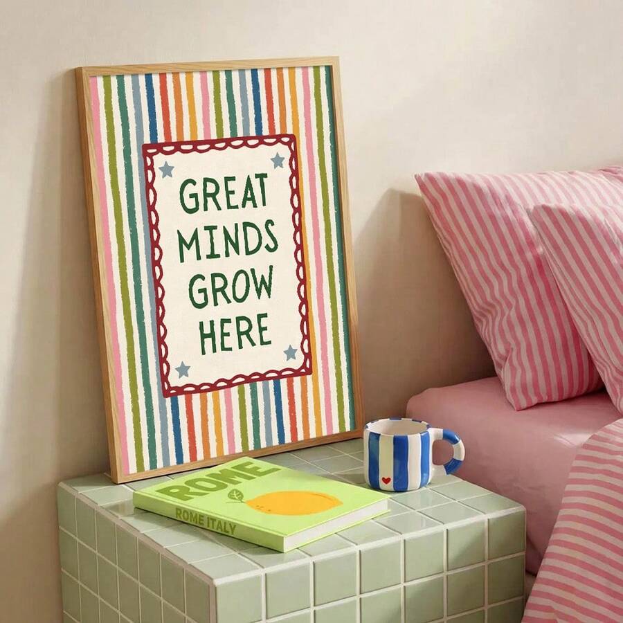 Colorful classroom slogan artwork styled beside a pink cushion and school books