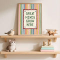Great Minds Grow Here print displayed on a classroom shelf with books and toys