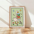 Cartoon goose with book stack and moon displayed in a simple wood frame against a sunlit wall