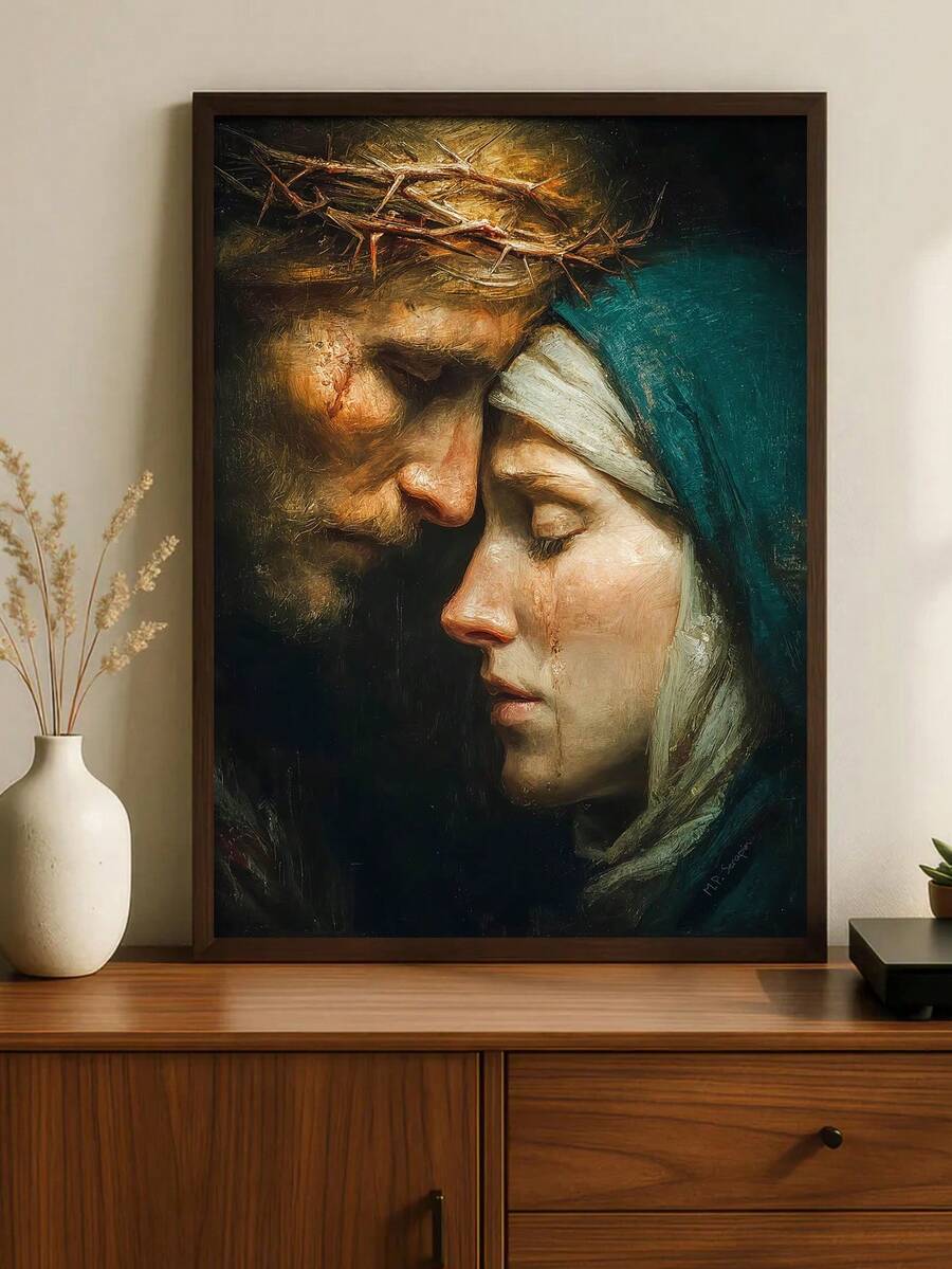 Dark framed close-up of Mary and Jesus displayed on a warm wood console beside a white vase