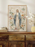 Pastel floral Mary canvas styled in a pale gold frame above a rustic wooden sideboard