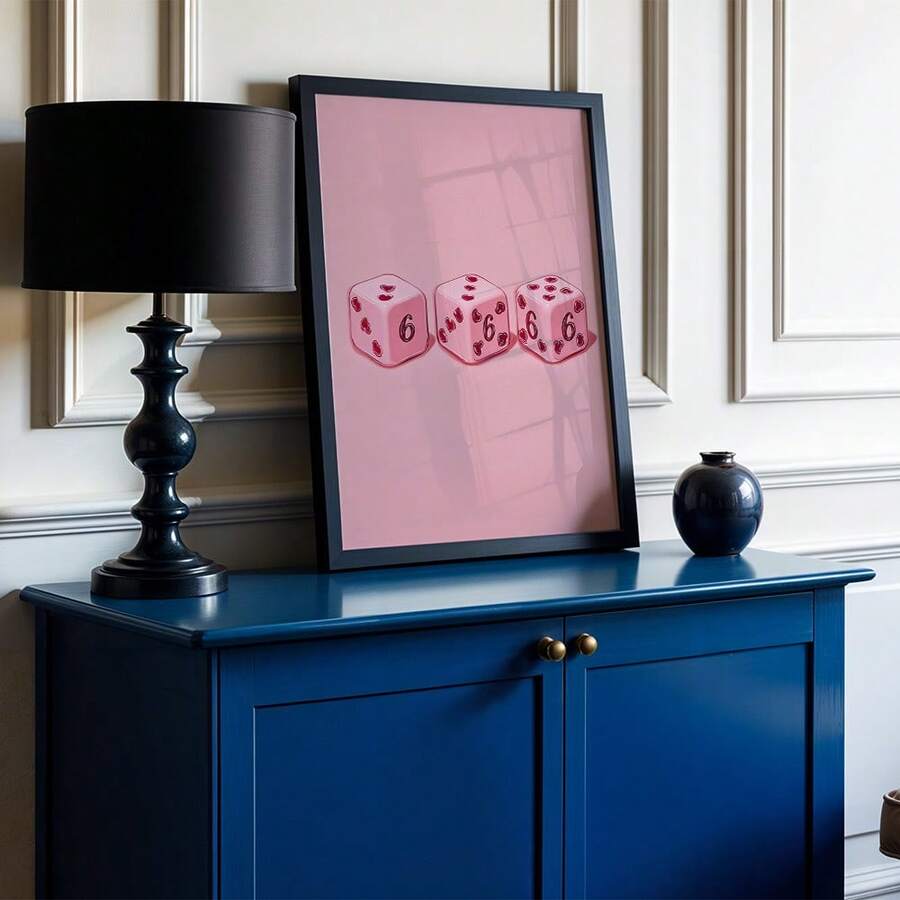 Pink dice canvas poster in a black frame on a blue sideboard