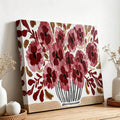 Close view of burgundy and dusty rose flowers with ochre leaves in a drawn vase