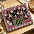 Close view of white flower and green vase artwork on a pink canvas print