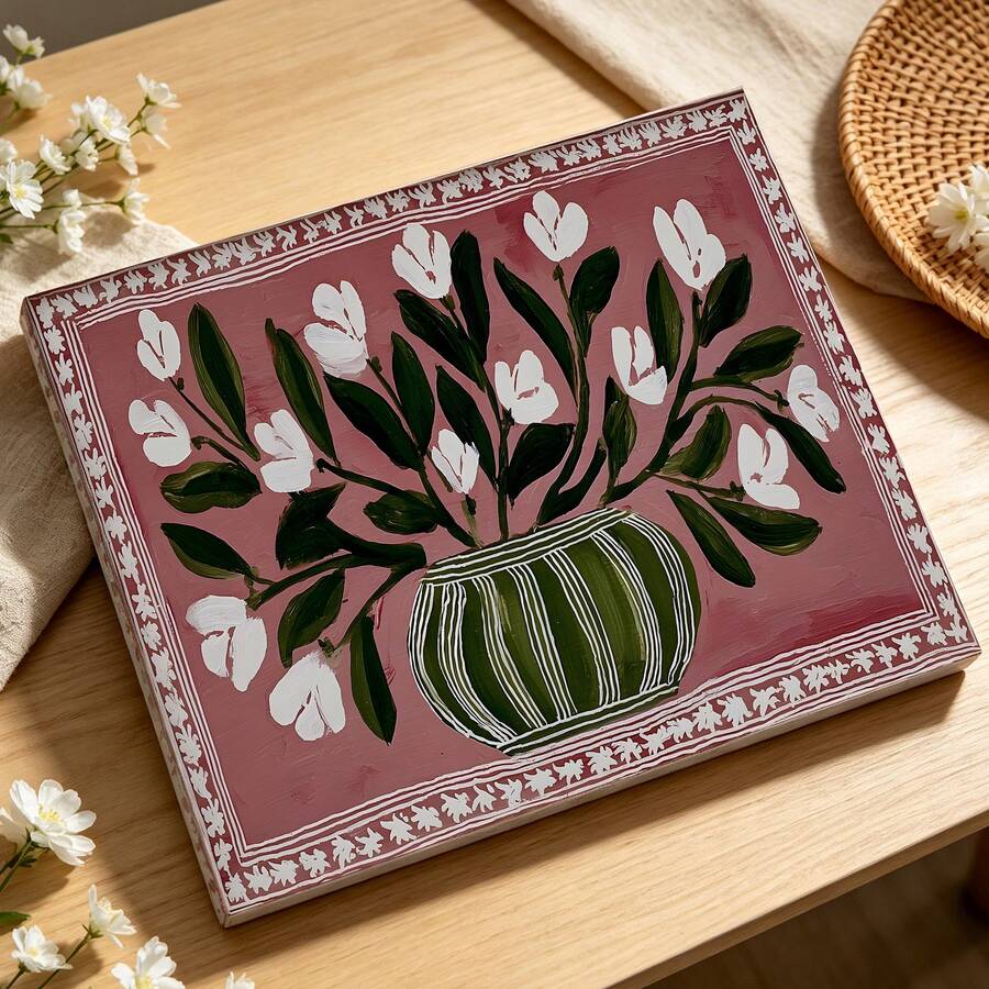 Close view of white flower and green vase artwork on a pink canvas print