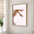 Pink martini fashion canvas poster in a gold frame beside a bright window and potted plant