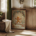 Holiday gingerbread swing art leaning near a wood cabinet and woven basket