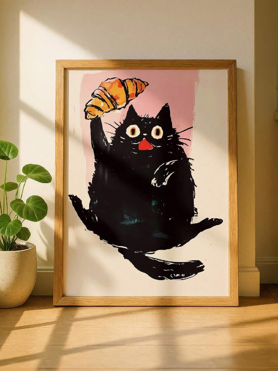 Framed black cat holding croissant canvas poster against a pink background
