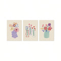 Unframed trio of hand-drawn flower vase canvases on a plain light background